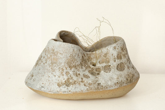 Sculptural ceramic vessel with textured white surface and delicate gold-tone wire